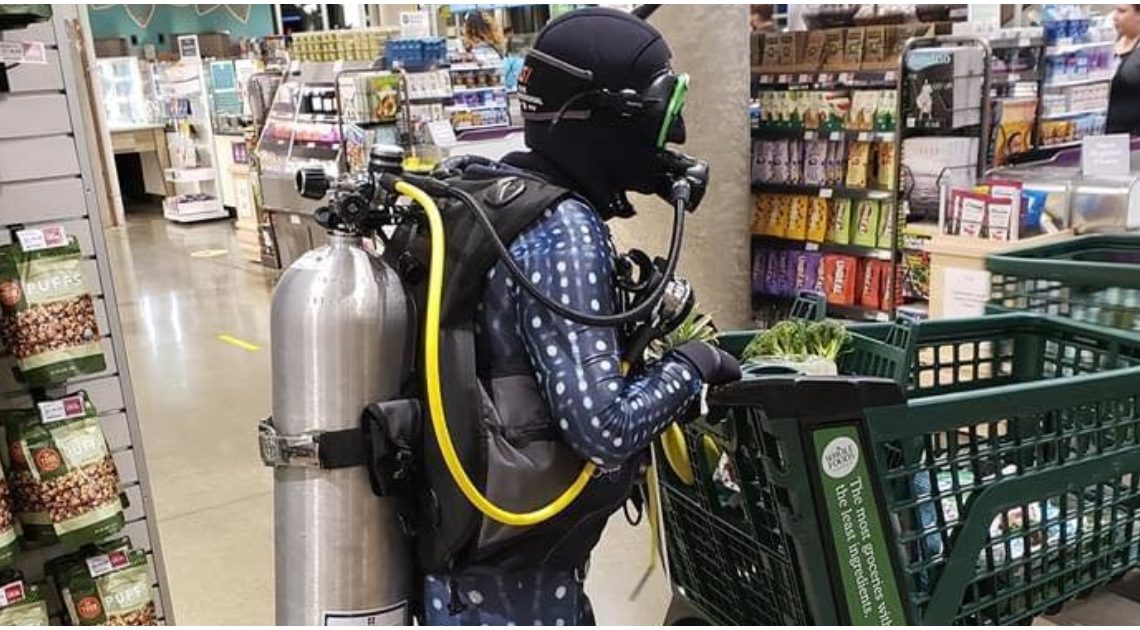 Homem veste equipamento de mergulho para ir às compras protegido contra o COVID-19